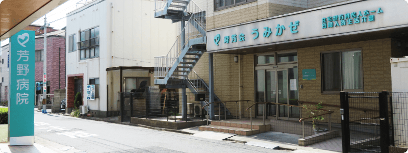 芳野病院の看板と道路を挟んで向かい側にうみかぜの正面玄関を写した写真